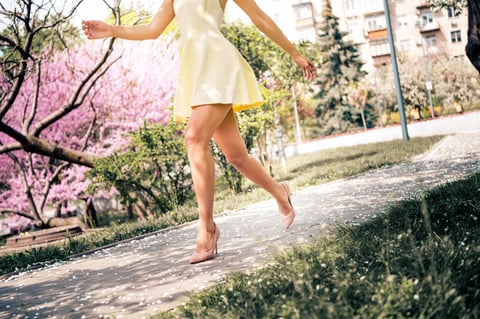 Young woman in yellow dress walking in park